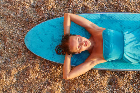 Surfing sport, summer time, time to relax and desire of adventure idea. Cute lady with wet hair on...