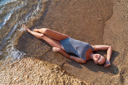 Girl sunbath on sand, sunny day for good tan. Idea of vacation trip, time to relax, summer time and...
