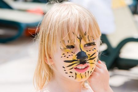 Girl with paint on his face in the poolの写真素材