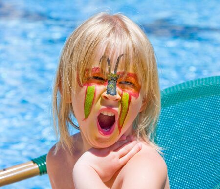 Girl with paint on his face in the poolの写真素材