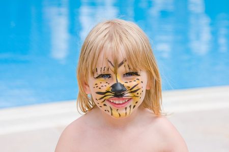 Girl with paint on his face in the poolの写真素材