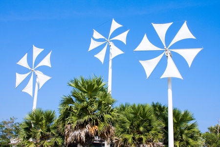 White wind turbine generating electricity on blue skyの写真素材