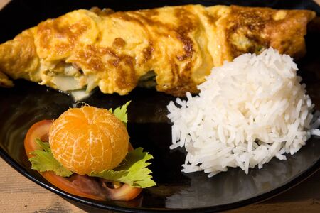 Breakfast fresh omelet on the black plateの写真素材