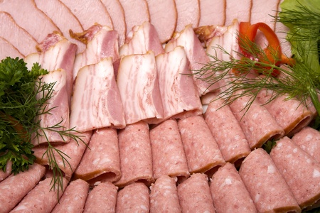 Meat assortment of beef, sausage and ham with greensの写真素材