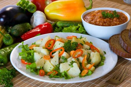 Boiled potatoes with vegetables on white plateの写真素材