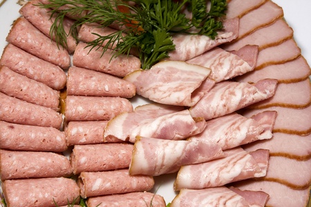 Meat assortment of beef, sausage and ham with greensの写真素材