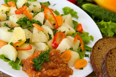 Boiled potatoes with vegetables on white plateの写真素材