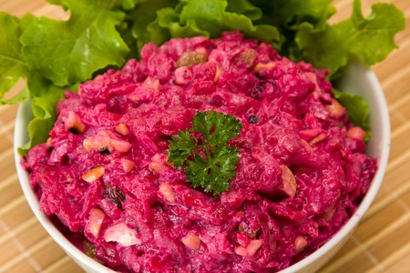 Salad with beets, dried plums, nuts on a plateの写真素材
