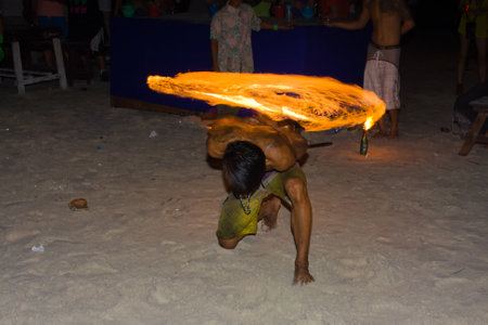 PHANGAN - JANUARY 08 : There are about 10,000 people every month at this Phangan beach Full moon party, on January 08, 2012 in Koh Phangan , Thailand . Fire dancer on a beach - blurのeditorial素材