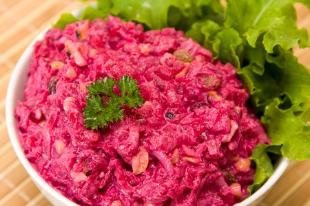 Salad with beets, dried plums, nuts on a plateの写真素材