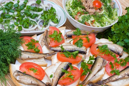 Sandwiches with sprats and tomatoes on a plateの写真素材