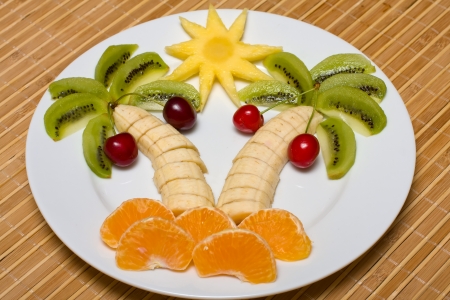 Creative fruit dessert with kiwi, banana,cherry and orange palm tree shapeの写真素材