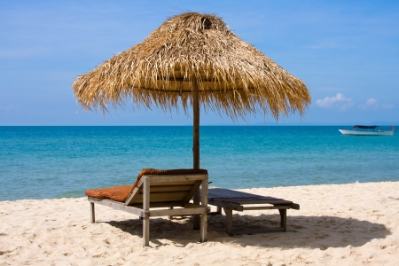 Sun loungers with an umbrella on the beachの写真素材