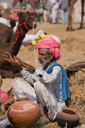 PUSHKAR, INDIA - NOVEMBER 21: An unidentified man attends the Pushkar fair ( Pushkar Camel Mela ) on November 21, 2012 in Pushkar, Rajasthan, India. Pilgrims and camel traders flock to the holy town for the annual fair.のeditorial素材