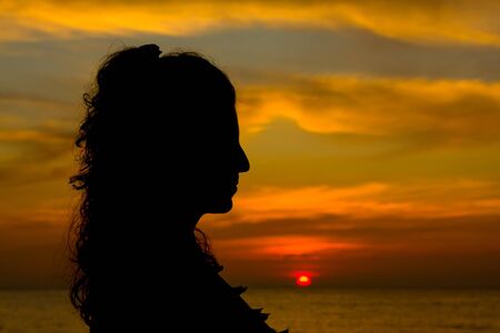 Silhouette of a girl at sunsetの写真素材