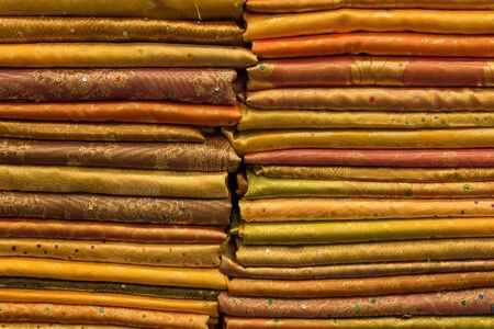 Heap of cloth fabrics at a local market in India. Close up .