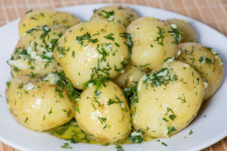 Boiled young potatoes in white plateの写真素材