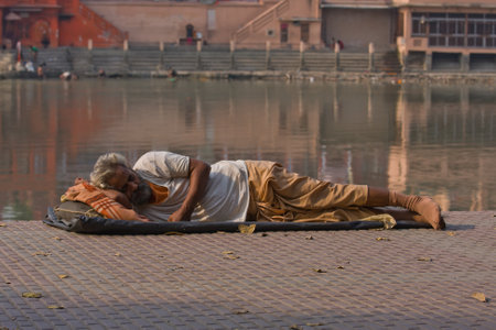 HARIDWAR, INDIA - NOV 8: An unidentified homeless man sleeps on the sidewalk near the River Ganges on November 8, 2012 in Haridwar, India. Poor Indians flock to Haridwar for charity.のeditorial素材