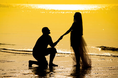 Bride and groom on the beach during sunsetの写真素材