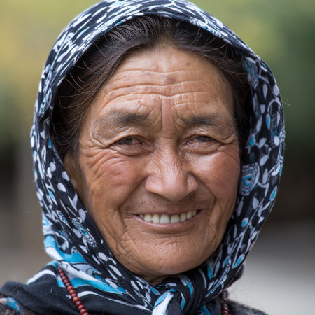 LEH IN LADAKH, INDIA - SEPTEMBER 03 2014: Old unidentified local woman sitting outdoor in Leh. The majority of the local population are descendant of Tibetan.のeditorial素材