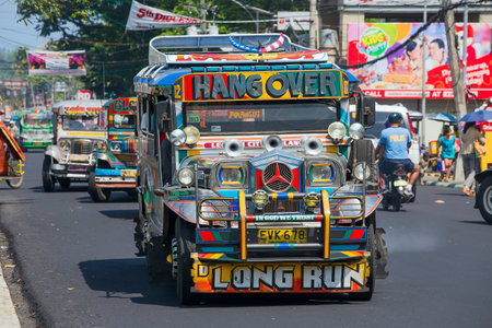 LEGAZPI, PHILIPPINES - MARCH 18: Jeepneys passing, Filipino inexpensive bus service. Jeepneys are the most popular means of public transportation in the Philippines.のeditorial素材