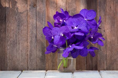 Closeup beautiful bouquet of orchids flower on a wooden background