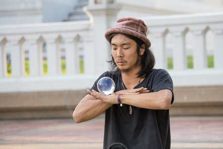BANGKOK , THAILAND - JANUARY 22, 2015: Unknown street performer juggling glass bowl in front of passers-by on the street Khao San Road in Bangkokのeditorial素材