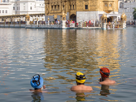 AMRITSAR, INDIA - SEPTEMBER 28, 2014: Unidentified Sikhs men visiting the Golden Temple in Amritsar, Punjab, India. Sikh pilgrims travel from all over India to pray at this holy site.のeditorial素材