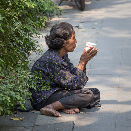 BANGKOK,THAILAND - JANUARY 8, 2015: Unknown Thai old beggar woman waits for alms on a streetのeditorial素材