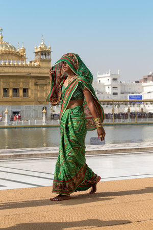 AMRITSAR, INDIA - SEPTEMBER 29, 2014: Unidentified Rajasthani woman visiting the Golden Temple in Amritsar, Punjab, India. Sikh pilgrims travel from all over India to pray at this holy site.のeditorial素材