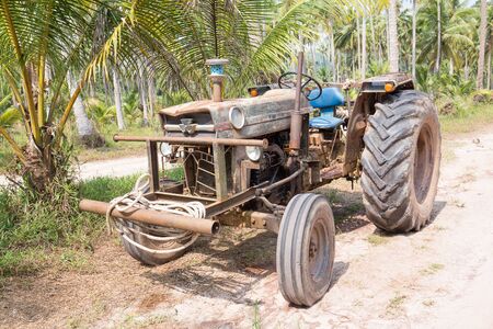 Very old tractor on a dirt road in the jungle, Thailandの写真素材