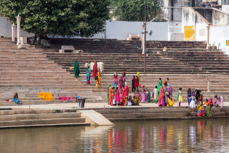 PUSHKAR, INDIA - OCTOBER 27, 2014: Unidentified people perform puja - ritual ceremony at holy Sarovar lake. Pushkar - famous worship place in Indiaのeditorial素材