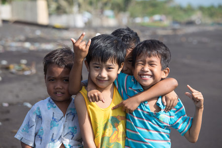 LEGAZPI, PHILIPPINES - MARCH 18, 2014: Unidentified poor but healthy children group portrait on the beach with volcanic sand near Mayon volcanoのeditorial素材
