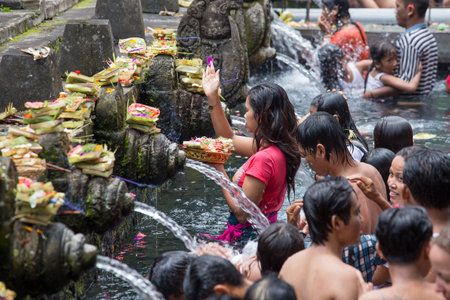 BALI, INDONESIA - MARCH 29, 2015 : Unidentified Balinese families come to the sacred springs water temple of Tirta Empul in Bali, Indonesia to pray and cleanse their soulのeditorial素材
