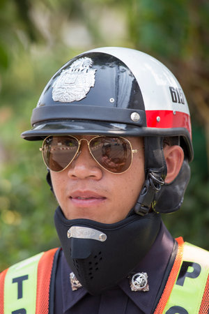 PAI, THAILAND - APRIL 11, 2015 : Unidentified traffic police officer works on a busy road. Police regularly direct traffic in busy areas.のeditorial素材