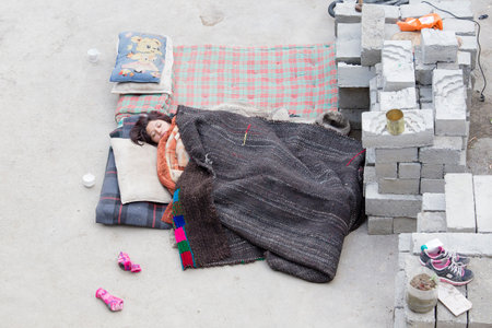 LAMAYURU, INDIA - JUNE 14, 2015: Unknown Indian girl sleeping on the street. During the festival in the Tibetan monastery of Lamayuru accommodation for all is not enoughのeditorial素材
