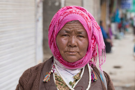 LEH, INDIA - JUNE 21, 2015: Unknown beggar woman begging on the street in Leh, Ladakh. Poverty is a major issue in Indiaのeditorial素材