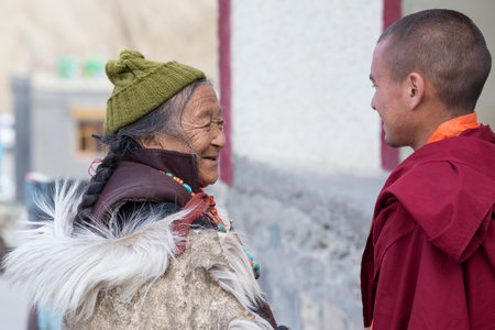 LAMAYURU, INDIA - JUNE 14, 2015: Unidentified buddhist old woman and monk during Tsam mystery in time of Yuru Kabgyat festival at Lamayuru Gompa, Ladakh, North Indiaのeditorial素材