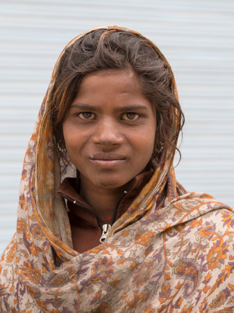 LEH, INDIA - JUNE 24, 2015: Unknown poor girl begs for money from a passerby on the street in Leh, Ladakh. Poverty is a major issue in Indiaのeditorial素材