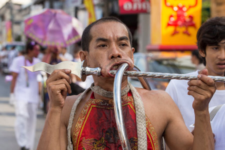 PHUKET, THAILAND - OCT 17, 2015: Chinese thai monk possessed by his god walks with his mouth pierced in Vegetarian Festival at Phuket Town. Festival is a famous annual also known as Nine Emperor Godsのeditorial素材