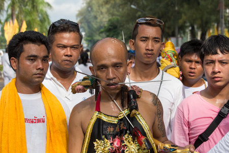 PHUKET, THAILAND - OCT 17, 2015: Chinese thai monk possessed by his god walks with his mouth pierced in Vegetarian Festival at Phuket Town. Festival is a famous annual also known as Nine Emperor Godsのeditorial素材