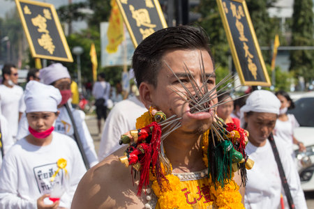 PHUKET, THAILAND - OCT 17, 2015: Chinese thai monk possessed by his god walks with his mouth pierced in Vegetarian Festival at Phuket Town. Festival is a famous annual also known as Nine Emperor Godsのeditorial素材