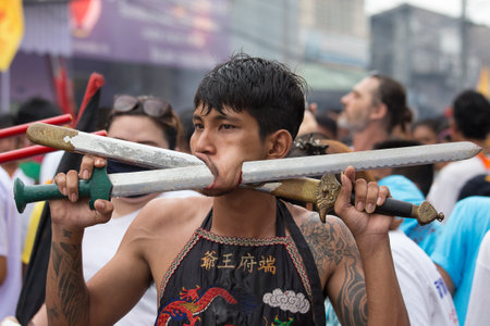 PHUKET, THAILAND - OCT 18, 2015: Chinese thai monk possessed by his god walks with his mouth pierced...