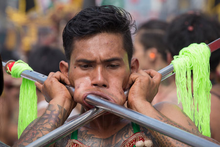 PHUKET, THAILAND - OCT 18, 2015: Chinese thai monk possessed by his god walks with his mouth pierced in Vegetarian Festival at Phuket Town. Festival is a famous annual also known as Nine Emperor Godsのeditorial素材
