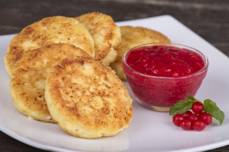 Cheese pancakes with berry jam in white plate. Close upの写真素材