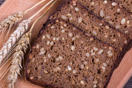 Fresh bread and wheat on the wooden, close up