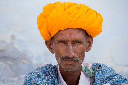 PUSHKAR, INDIA - OCTOBER 25, 2014: Unidentified Indian man, sits on the ghat along the sacred Sarovar lake. Pushkar - famous worship place in Indiaのeditorial素材