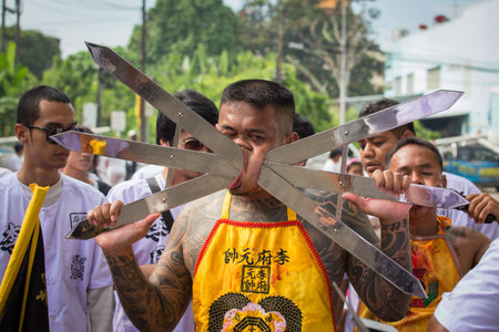 PHUKET, THAILAND - OCT 18, 2015: Chinese thai monk possessed by his god walks with his mouth pierced in Vegetarian Festival at Phuket Town. Festival is a famous annual also known as Nine Emperor Godsのeditorial素材