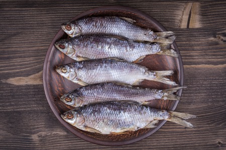Dry fish on a wooden background, close upの写真素材
