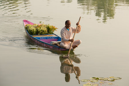 SRINAGAR, INDIA - JULY 07, 2015 : Lifestyle in Dal lake, people use Shikara, a small boat for transportation in the lake of Srinagar, India. Local florist with bouquets for sale on a boat tourのeditorial素材